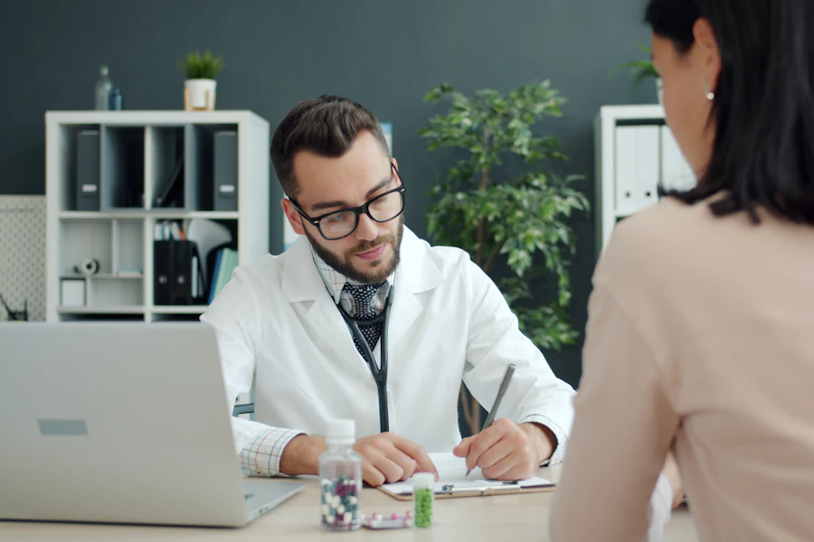 Médico tomando notas frente a una paciente durante un control